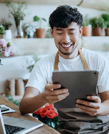 Gentleman smiling with iPad and laptop