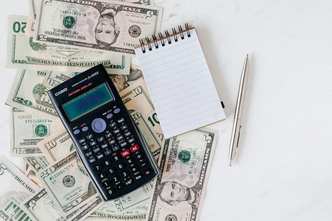 scattered bills, calculator, pen & paper