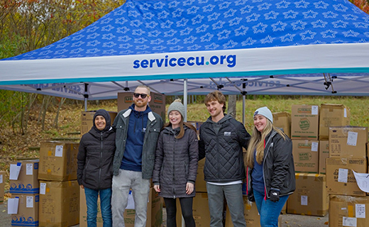 The Stay Warm team standing in front of many boxes of jackets