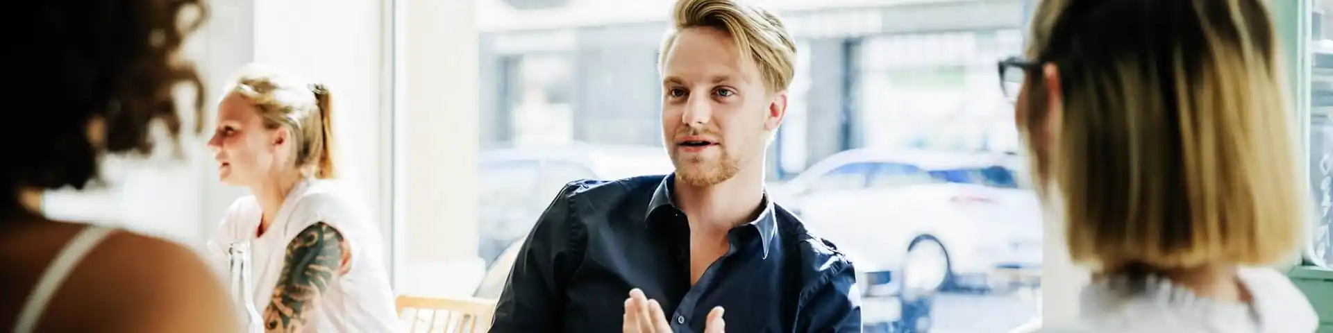 man mid-speech talking to two women