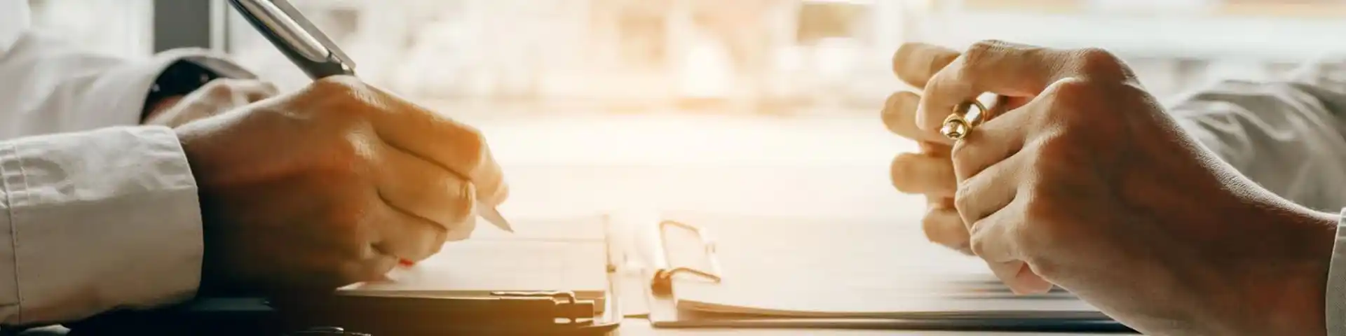 close up of hand signing documents