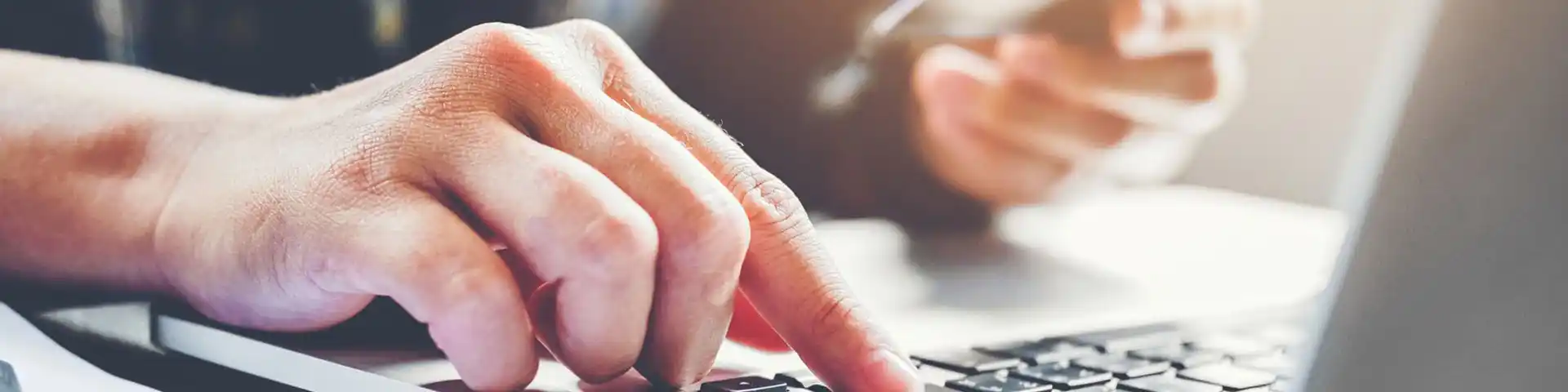 finger pressing a button on a laptop
