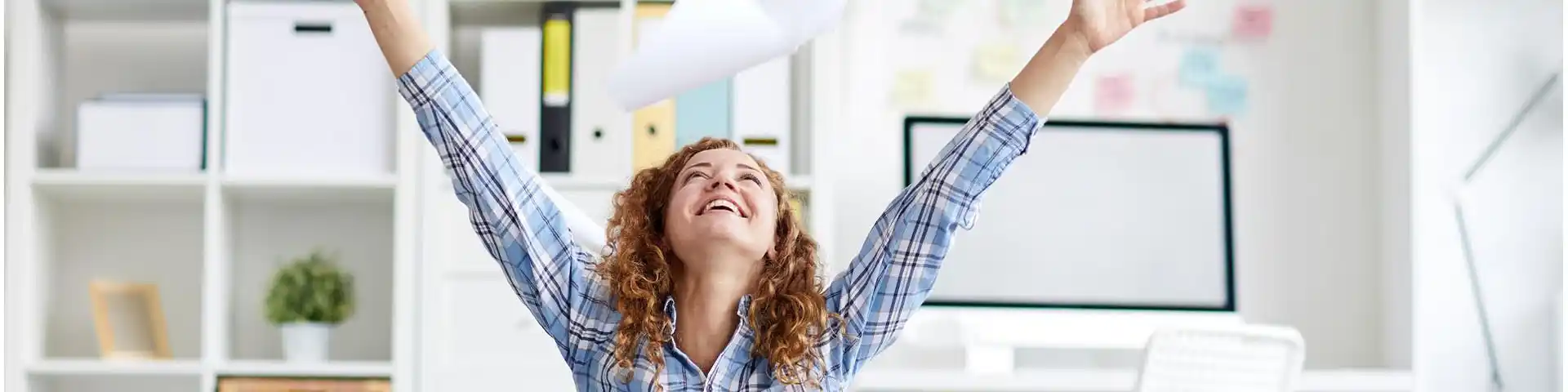 woman throwing papers in the air with excitement