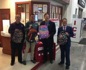 Proudly showing off the backpack donations in Salem, from left to right, are Service Credit Union Salem Branch Manager Justin Kimbrough, Service Credit Union Salem In-Store Branch Manager Scott DuCharme, New Hampshire Governor Chris Sununu and New Hampshire Department of Education Commissioner Frank Edelblut.