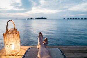 Person relaxing by water on a dock